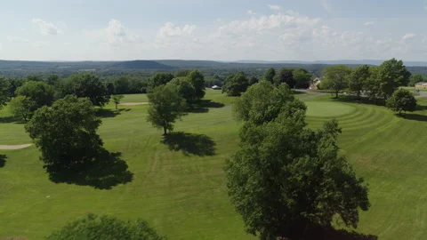 Drone shot flying over golf course, panning and flying over trees 스톡 동영상 153689408