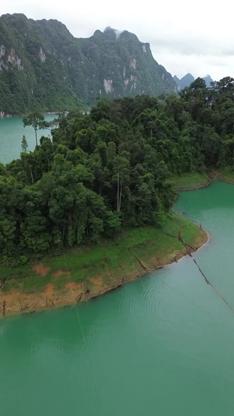 Drone shot flying over a lush green island in Khao Sok Stock Footage 336486551