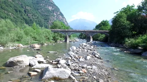 Drone shot - Flying over Swiss river and ancient roman bridge Stock Footage