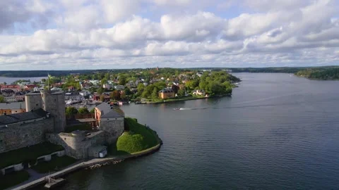 Drone shot flying parallel to a boat behind the Vaxholm Fortress in Sweden Stock Footage 263690122