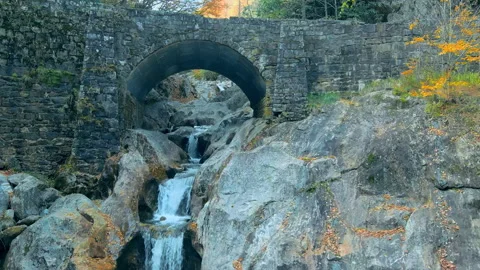 Drone shot flying toward waterfall and bridge Stock Footage 254603992