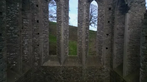 Drone shot flying towards the stone windows of the ruins of a 8th century abbey Stock Footage 237263032