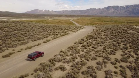 Drone shot of German Shepard running in front of a pickup truck in a desert. 스톡 동영상 89794679