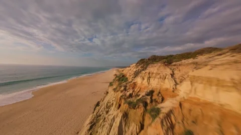Drone shot gliding above sandy shore and eroded cliffs Stock Footage 340225722