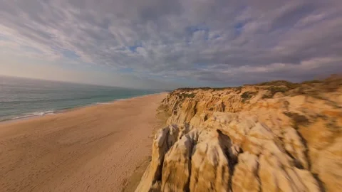 Drone shot gliding above sandy shore and eroded cliffs Stock Footage 340225738