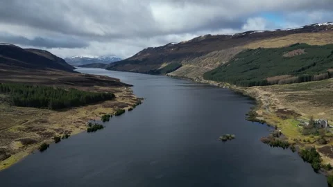 Drone shot gliding forward above Scottish river toward mountains Stock Footage 334331662