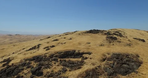 Drone shot gliding over mountain to reveal valley Stock Footage 129922801