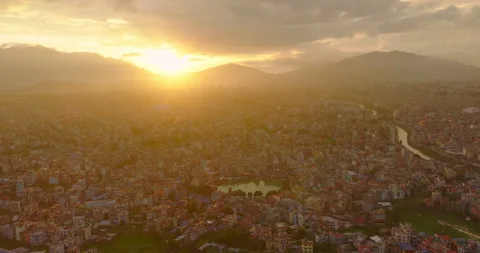 Drone shot of glowing sun setting over Kathmandu valley, Nepal urban cityscape Stock Footage 345654531
