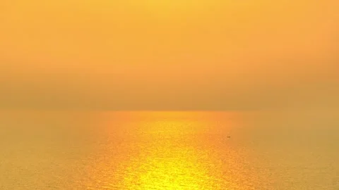 Drone shot of a glowing sunset spreading light over the ocean surface. Stock Footage 329664000