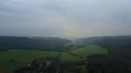 Drone shot gray clowdy foggy weather at low mountain range valley woodlands 4k or 4k+ Resolution