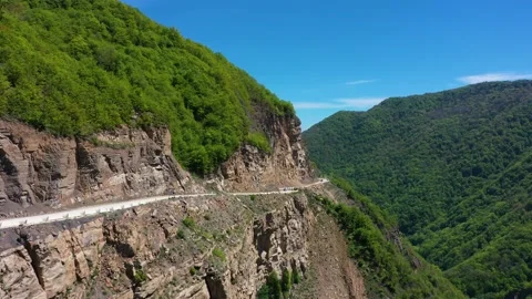 Drone shot from great height of multiple suv driving through convoluted mountain Video stock 171921092