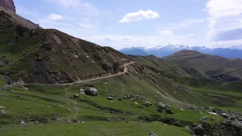 Drone shot from great height of multiple suv driving through convoluted mountain Video stock 172052282
