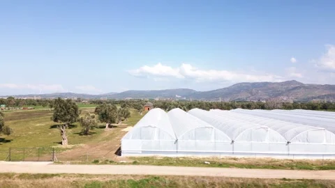 Drone shot of a greenhouse among the fields, trucking shot Stock Footage 270065357