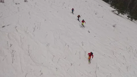 Drone shot of a group of four men skiing uphill. 動画素材 180622103