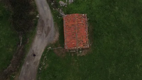 A drone shot of a guy walking a path with a house aside 動画素材 150362054