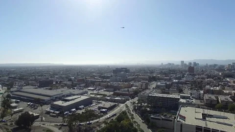 Drone shot of helicopter flying over mid city Los Angeles Stock Footage 88933429
