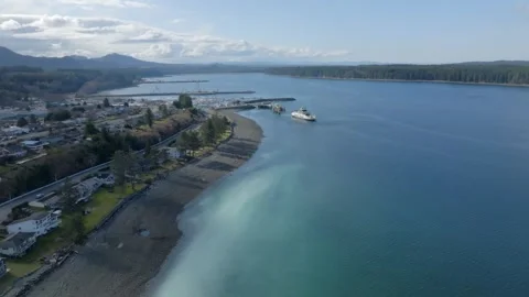 Drone shot of herring spawn happening on the shore of Port McNeill with ferry Stock Footage 345174552