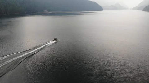 Drone Shot From Up High Of Boat Speeding Off Down A Lake Stock Footage