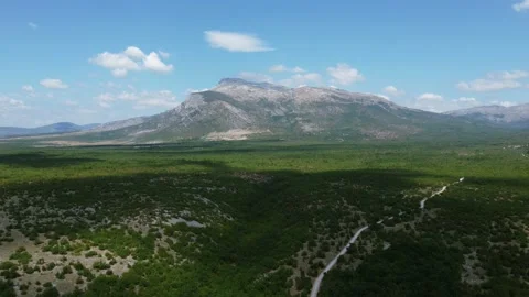 Drone shot of high mountain. Road through lowlands Video stock 231393016