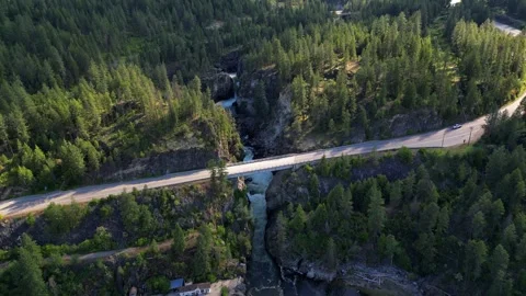 Drone shot of an highway bridge spanning over a wild river canyon in british Video stock 339074222