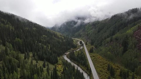 Drone shot of highway curving through misty Colorado canyon Stock Footage 336504756
