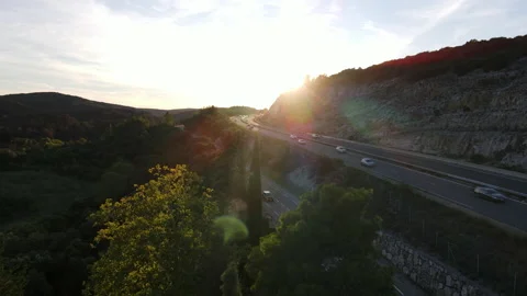 Drone shot of a highway surrounded by a forest during a sunset. Traffic is heavy Stock Footage 214918777