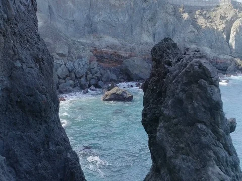 Drone shot of huge rock surrounded by powerful oceanic waves Stock Footage 83870735