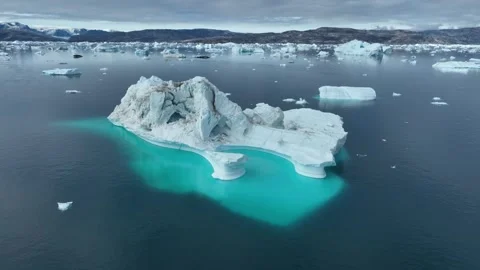 Drone shot of icebergs floating in a large fjord of East Greenland Video stock 332376373