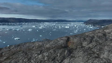 Drone shot of icebergs floating in a large fjord of East Greenland Video stock 332378126