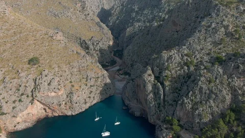 Drone shot of incredible beach between steep cliffs with white yachts Stock Footage 119437956
