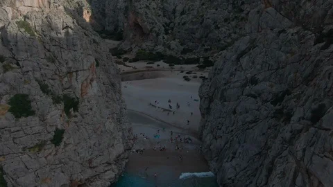 Drone shot of incredible beach between steep cliffs with white yachts Stock Footage 119439392
