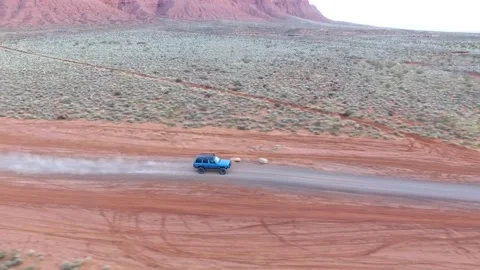 Drone shot of Jeep driving down a dirt road. Video stock 144583374