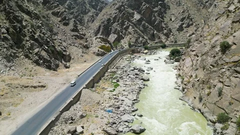 Drone Shot of KabuL River and Highway Road Traffic Under Shiwari Mountain Stock Footage 318069689