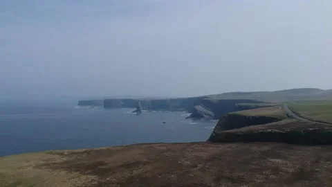 Drone shot of Kilkee Cliffs in Ireland with green landscape and ocean view Stock Footage