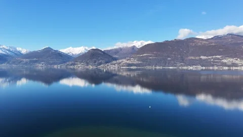 Drone shot of Lake Como with snow covered mountains and reflections Video stock 328010030