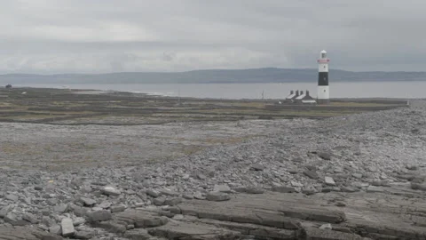 Drone shot of Landscape with Lighthouse in the Distance on Aran Island, Ireland Video stock 224818271