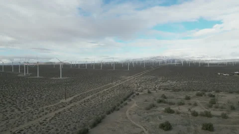 Drone shot of large rotating blades within wind turbines farm Video stock 235770470