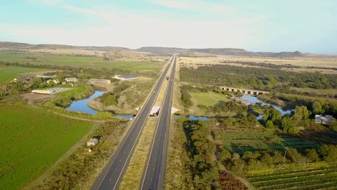 Drone shot of long straight road over a river Stock Footage 90485308