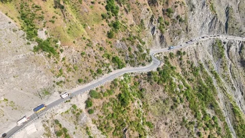 Drone shot of long vehicle queue on narrow cliffside highway pass India. Stock-Footage 337615173