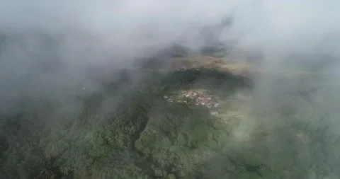 Drone shot looking down at a forest settlement with a faint rainbow appeari.. Video stock 327752676