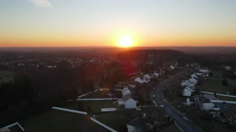 Drone shot lowering and rising of a sunset over a quaint and quiet suburban  Stock Footage 228699776