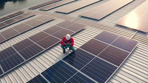 Drone shot, Male engineer maintaining solar cell panels on building rooftop. Stock Footage 228868484