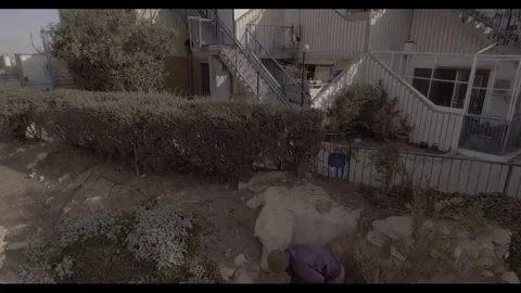 Drone shot of man digging in garden out to city Stock Footage 82231146