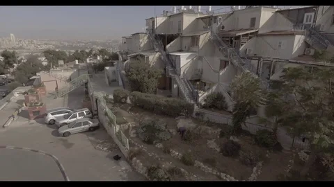Drone shot of man digging in garden out to city 3 Stock Footage 82231216