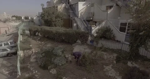 Drone shot of man digging in garden out to city 4 Stock Footage 82639507