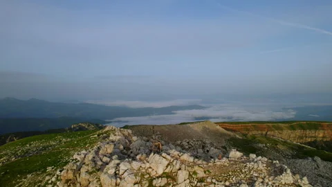 Drone Shot of Man standing Alone on Mountain Top Summit during Sunrise Stock Footage 220551924
