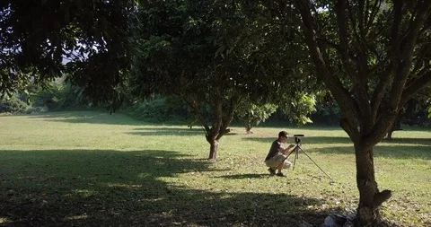 Drone shot a man is taking video in park in Chiang Mai Thailand Stock Footage 100744864