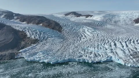 Drone shot of a massive glacier ending at the ocean in East Greenland Stock Footage 332379538