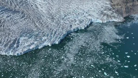 Drone shot of a massive glacier ending at the ocean in East Greenland Video stock 332379676
