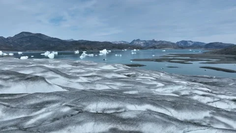 Drone shot of a massive glacier ending at the ocean in East Greenland Video stock 332380041
